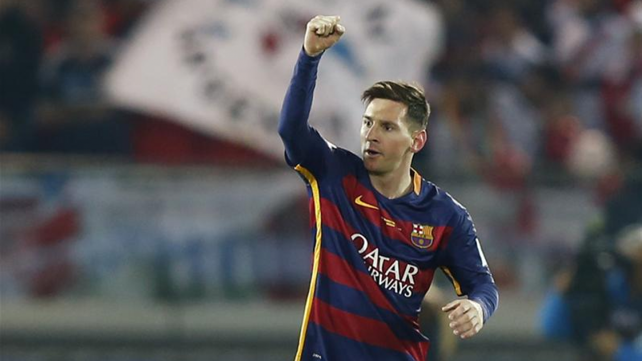 Messi raises arm in celebration 