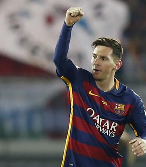 Messi raises arm in celebration 