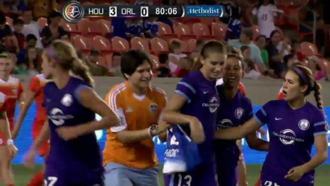 A pitch invader goes after Alex Morgan.