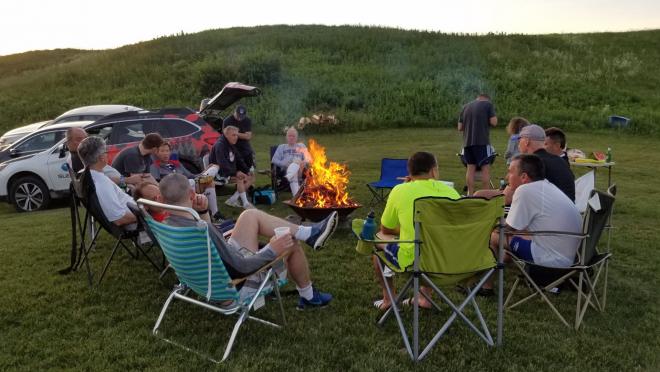 Eric Brief and fellow teammates sit around the campfire enjoying post-game socializing.